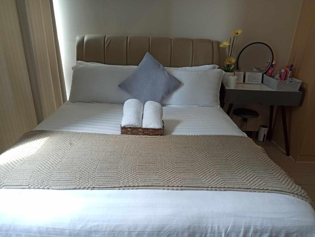 una camera da letto con un letto e due asciugamani di Cozy 1BR UPTOWN PARKSUITES Tower1 BGC a Manila