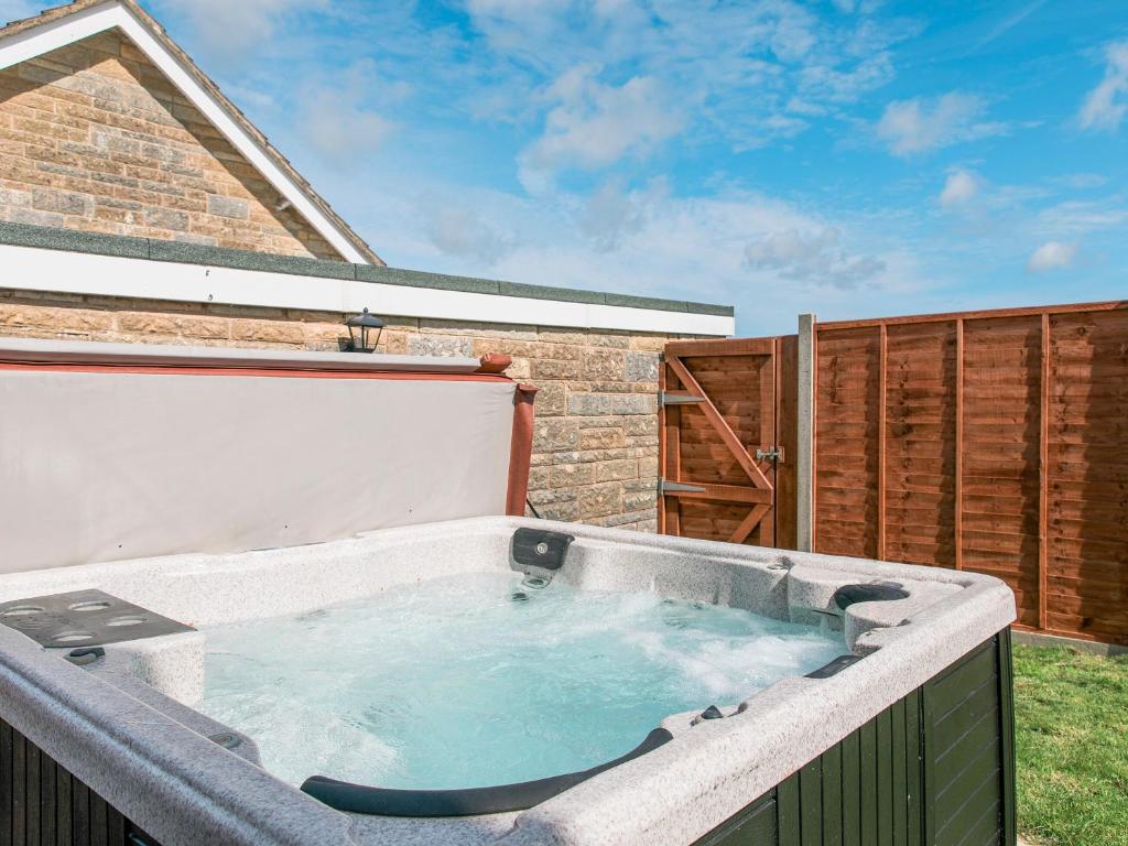 a hot tub on the back of a house at Woodpeckers Rest in Niton