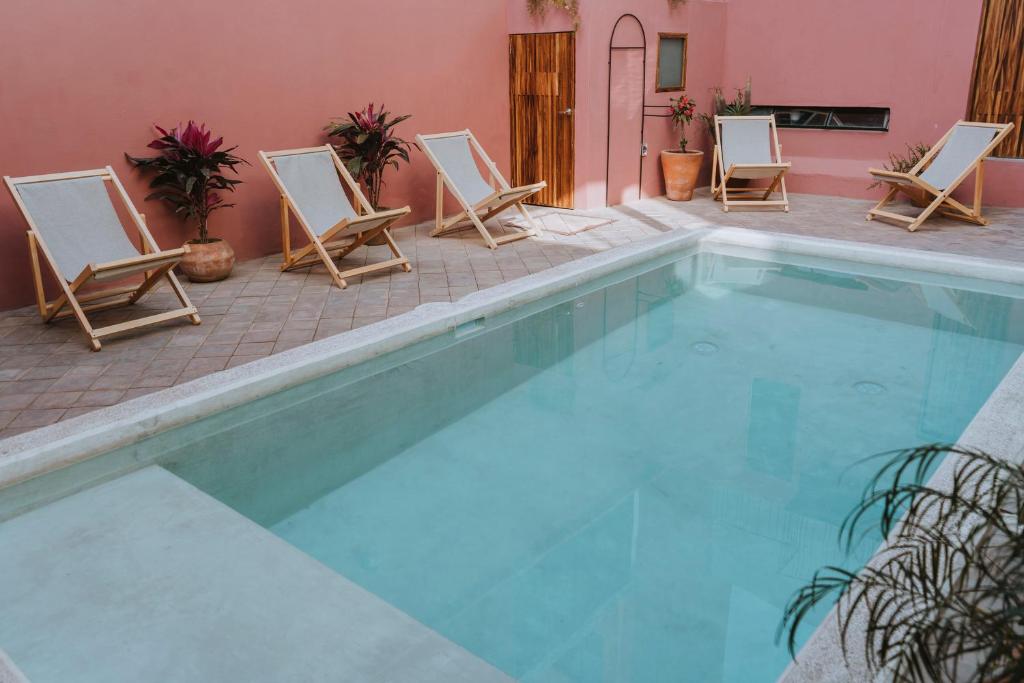 un grupo de sillas y una piscina en Hotel Boutique Casa de Arte Oaxaca, Art Gallery & Pool, en Oaxaca City
