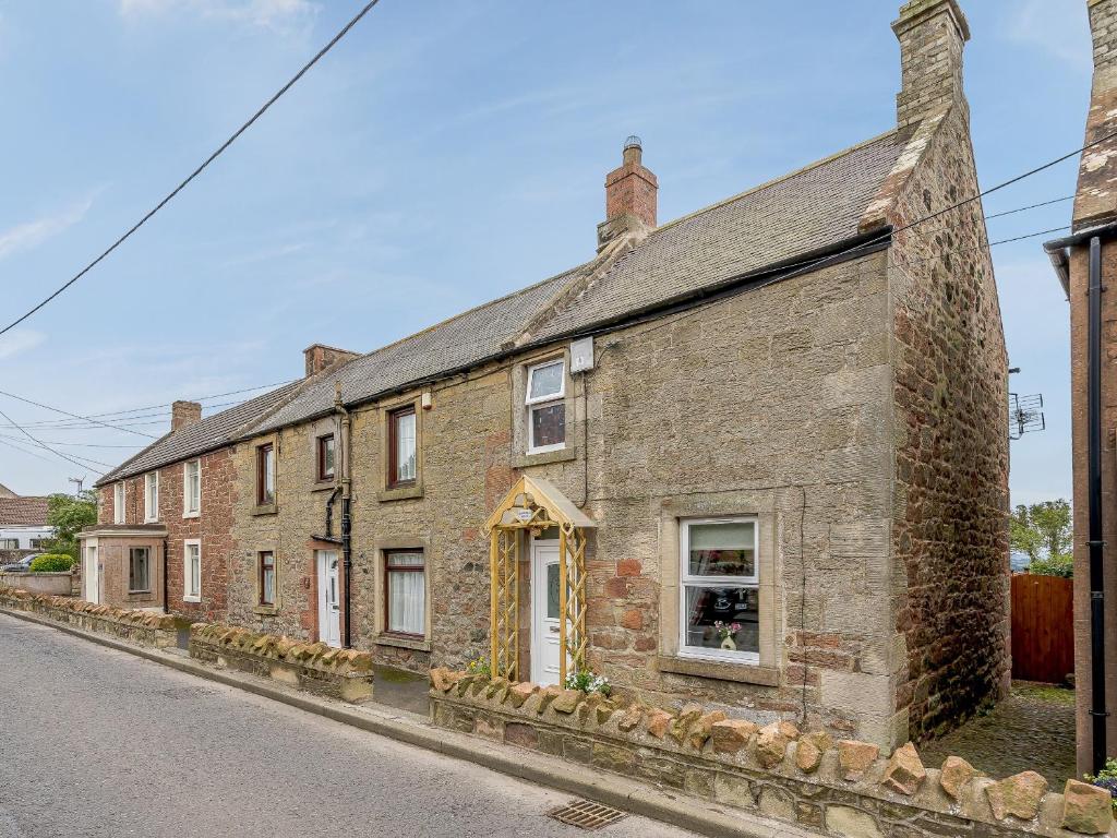 an old brick house on the side of a street at Margaret House in Chirnside