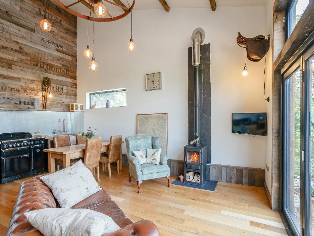 a living room with a couch and a wood stove at Outshot Barn in Dorstone