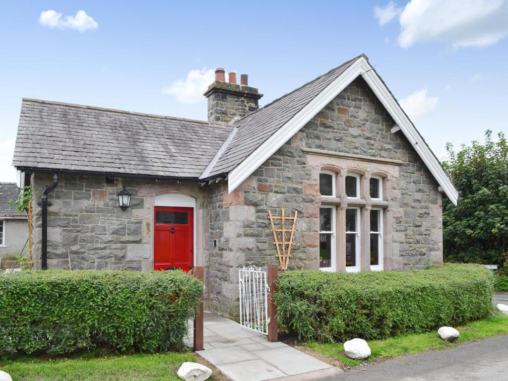 una pequeña casa de piedra con puerta roja en Lealholme, en Bassenthwaite