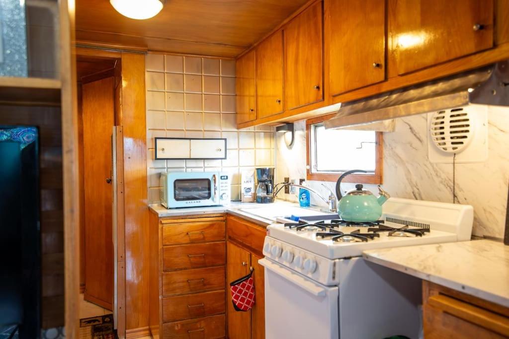 una pequeña cocina con fogones y fregadero en Vintage Trailer - Cute Spot for Budget Travelers en Anchorage