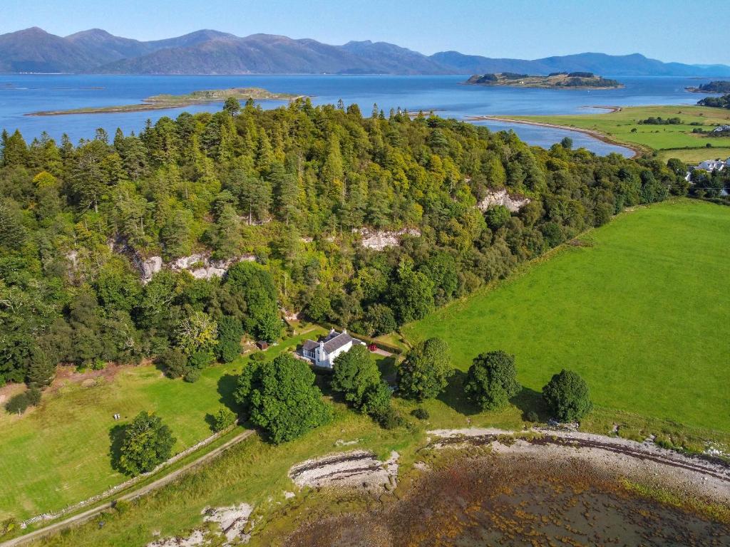 an aerial view of a house on a hill next to a lake at Cliff Cottage in Port Appin