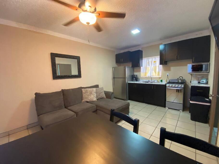 een keuken en een woonkamer met een bank en een tafel bij Departamento céntrico in Tijuana