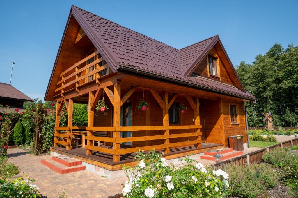 una pequeña casa de madera con techo marrón en Uroczysko Trzyrzeczki, en Dąbrowa Grodzieńska-Wieś