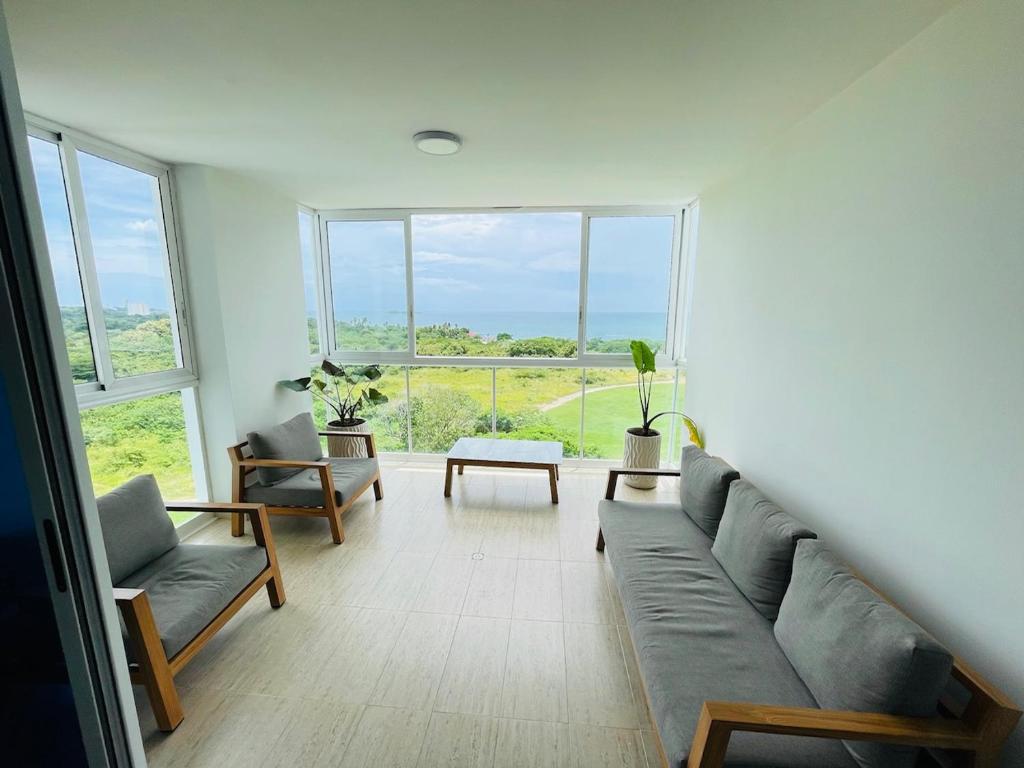 - un salon avec un canapé et une grande fenêtre dans l'établissement Panama's Paradise Playa Blanca Ocean & Pool View, à Río Hato