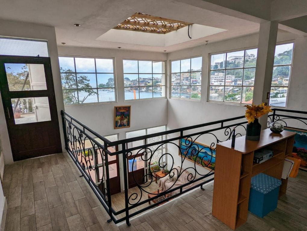een kamer met een trap met ramen en een tafel bij CASADUNN Next to Sababa Resort in San Pedro La Laguna