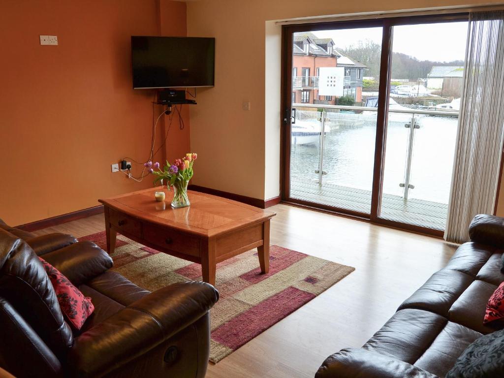 a living room with a couch and a coffee table at Kestrel Cottage in Horning
