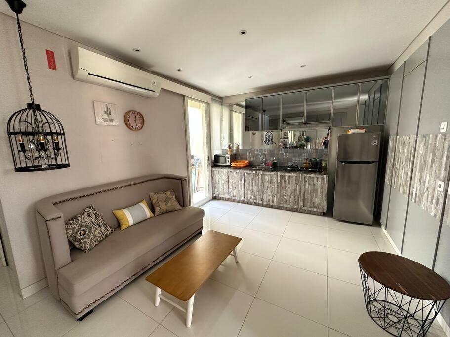 a living room with a couch and a kitchen at Private Cozy House in Pakuwon in Surabaya