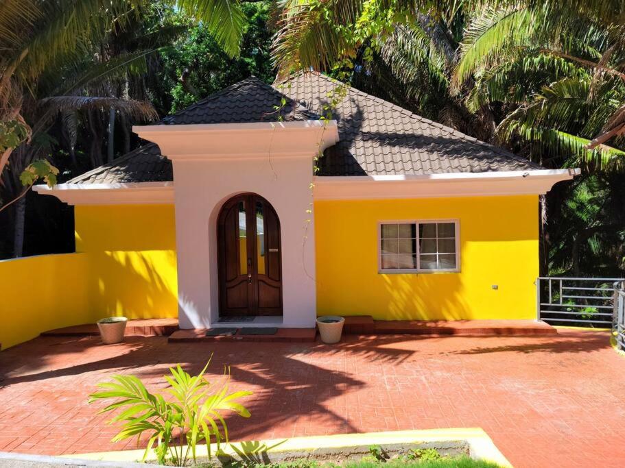 una casa amarilla con una puerta delante en Spacious & Spotless new house, 4 BRs, en Roatan