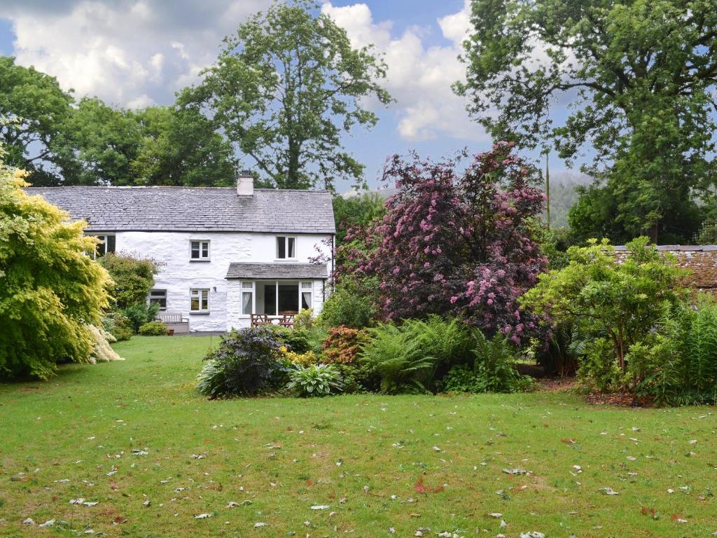 a white house with a garden in front of it at Sunny Beck in High Nibthwaite