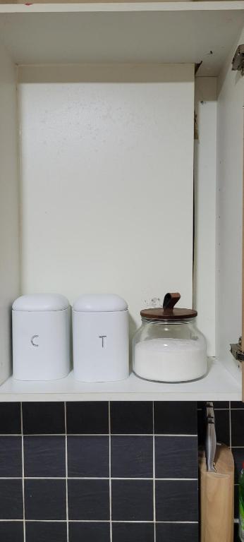 a kitchen shelf with four containers on it at 15 Decent Homes in Dukinfield