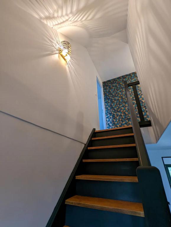 a staircase in a house with blue and white walls at Maison au calme dominant la ville d&#39;Evreux in Évreux