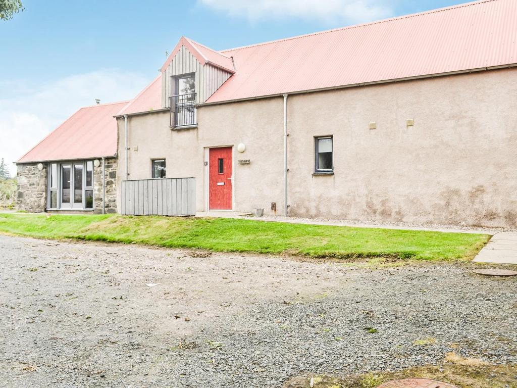 a large white building with a red door at The Byre - Uk33397 in Isle of Gigha