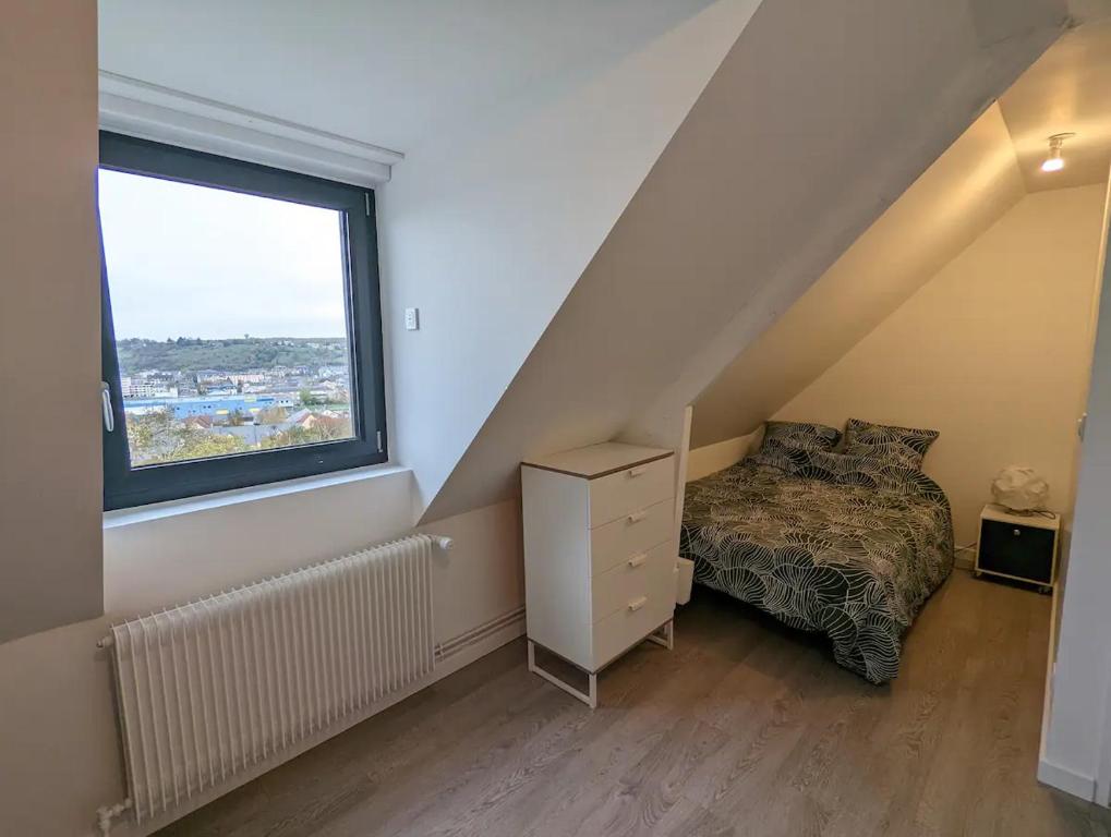 a bedroom with a bed and a large window at Maison au calme dominant la ville d&#39;Evreux in Évreux