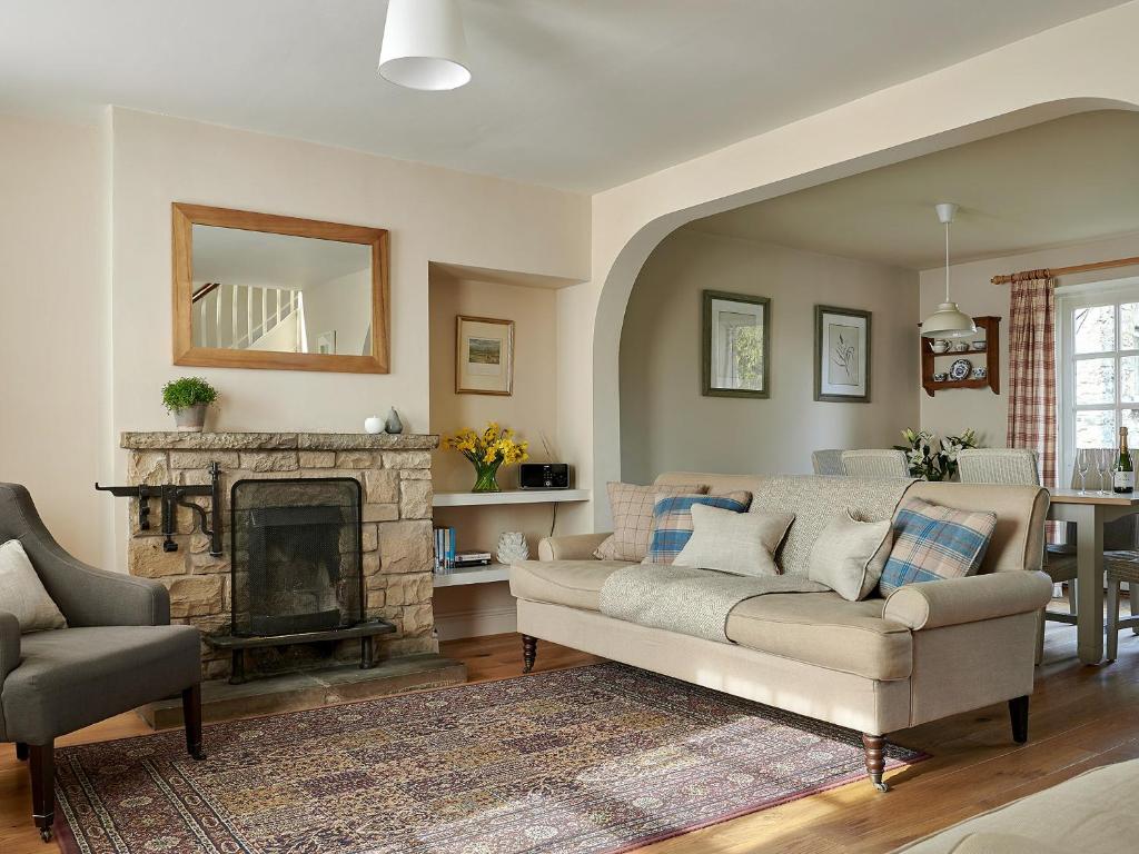 a living room with a couch and a fireplace at Levisham in Pickering