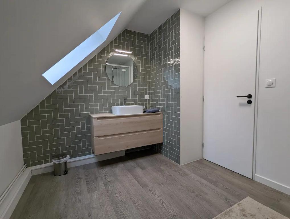 a bathroom with a sink and a staircase with a mirror at Maison au calme dominant la ville d&#39;Evreux in Évreux