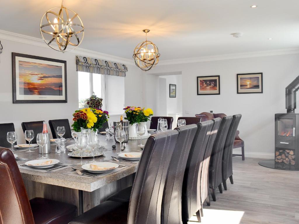 uma sala de jantar com uma mesa longa e cadeiras em Smithfield House em Tarbolton