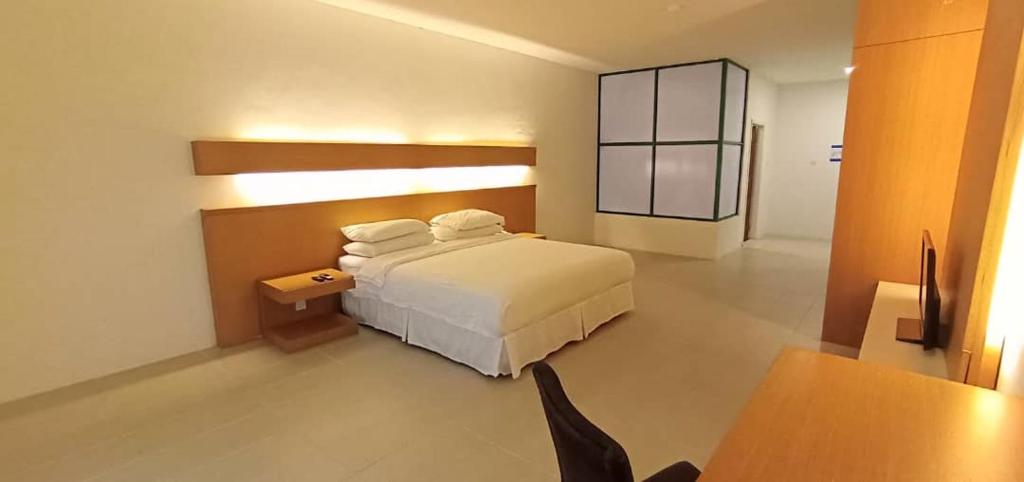 una camera con letto, tavolo e scrivania di Ara Hotel a Bau