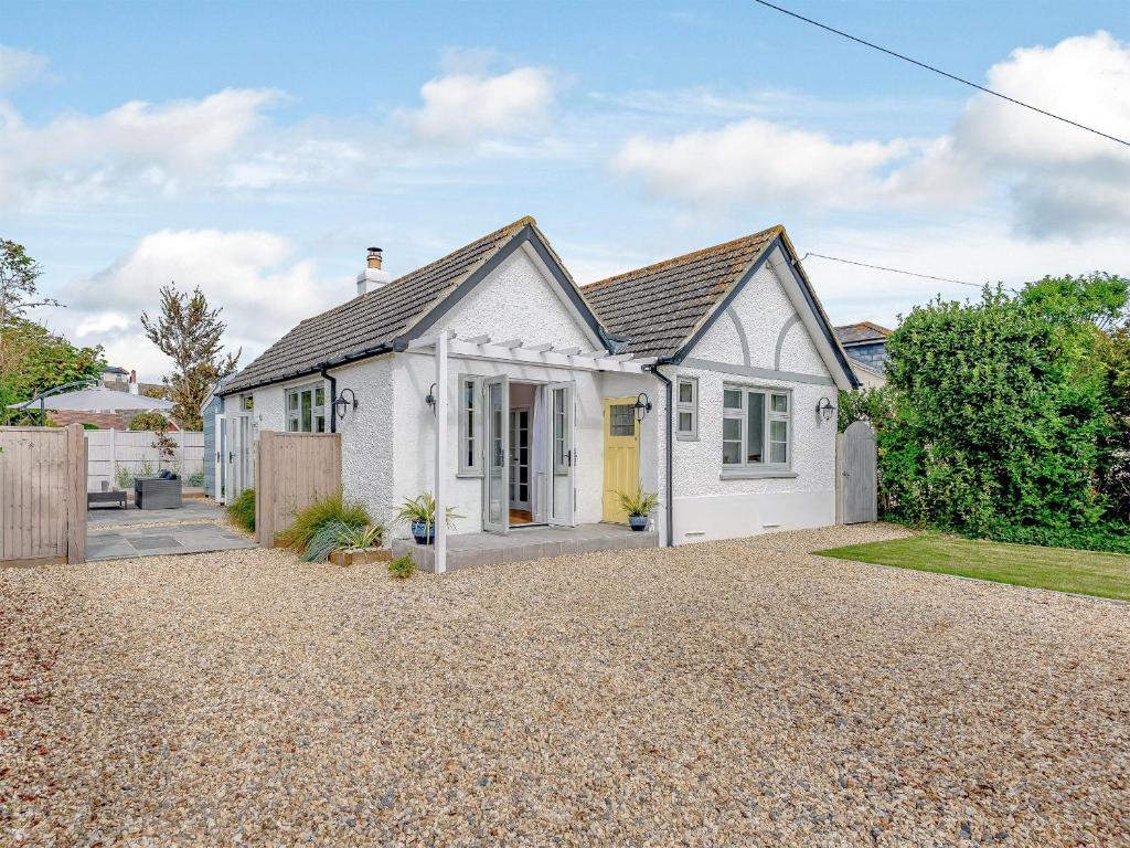 a white house with a gravel driveway at Beach Holme in East Wittering
