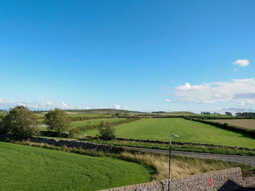 a large field of green grass with a blue sky at Wild Duck in Pennington