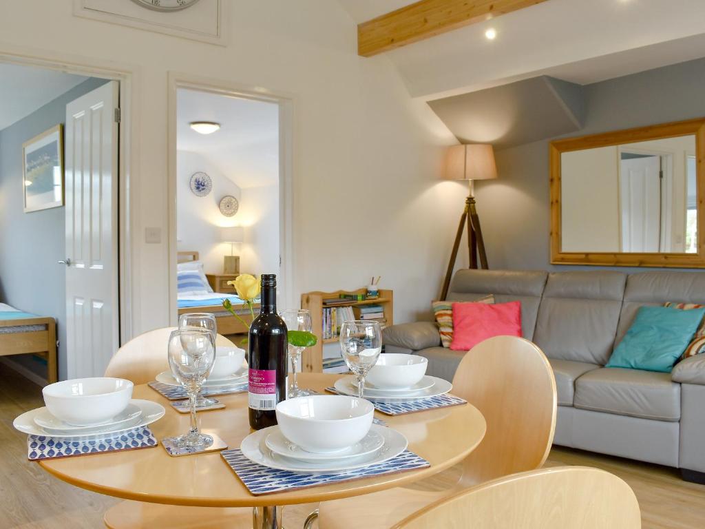 a dining room with a table with a bottle of wine at Purbeck Apartment in Chideock