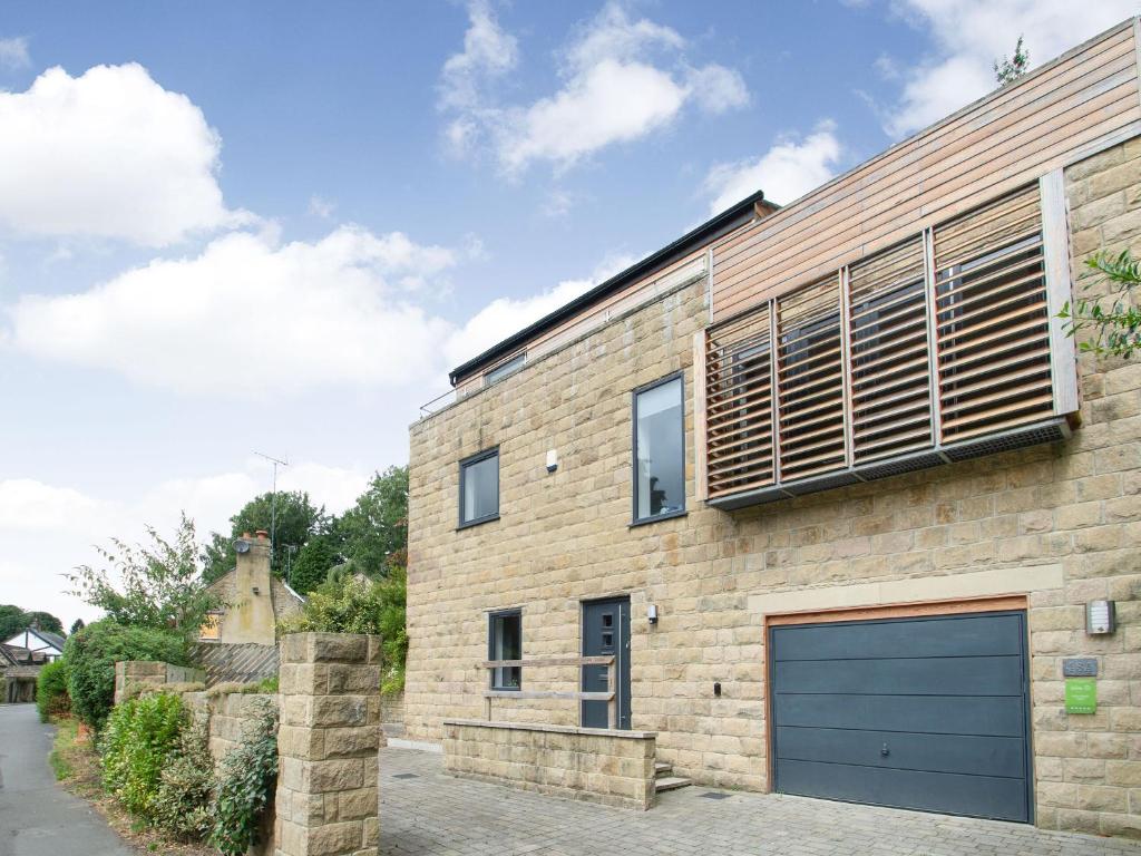 a brick house with a blue garage door at High Trees View in Knaresborough