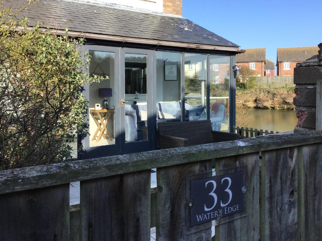 a screened in porch of a house next to a river at Waters Edge Holiday Home in Beadnell