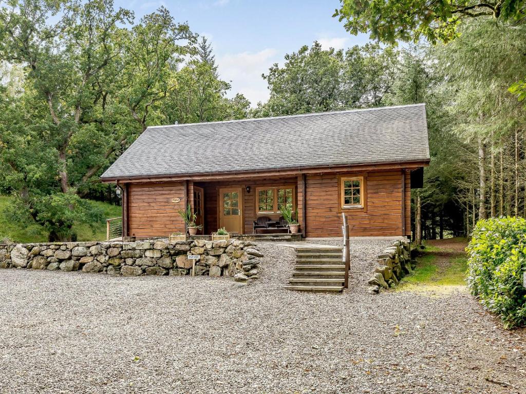 a log cabin with a stone wall at Larch in Killin