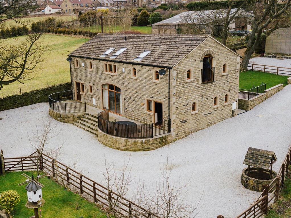 ein großes Backsteingebäude mit einem Zaun in der Unterkunft Cedar Barn - Uk33352 in Buttershaw