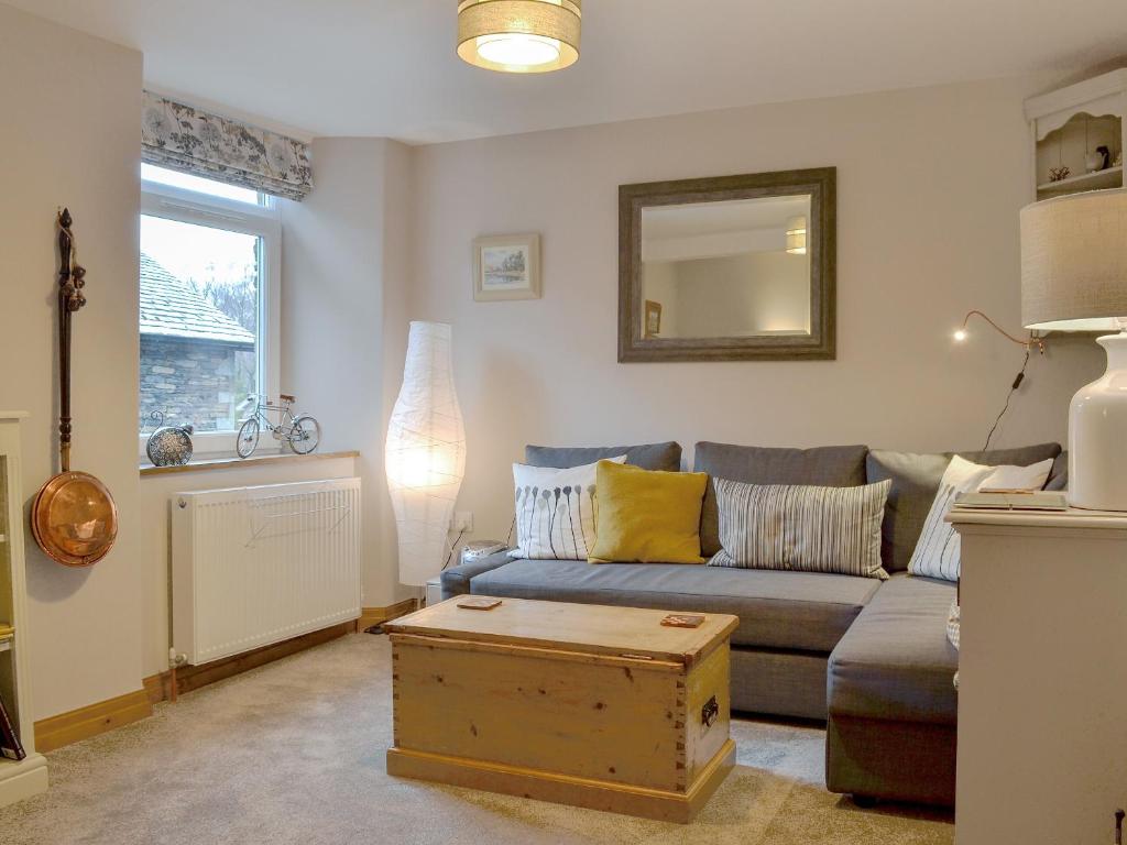 uma sala de estar com um sofá e um espelho em Little Nook em Ambleside
