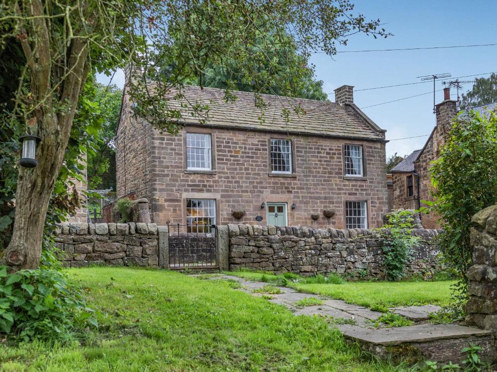 an old brick house with a stone fence at Catmint Cottage in Highpeak Junction