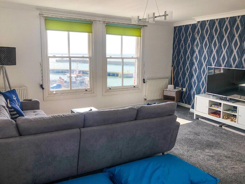 a living room with a couch and a television at East Apartment in Lowestoft