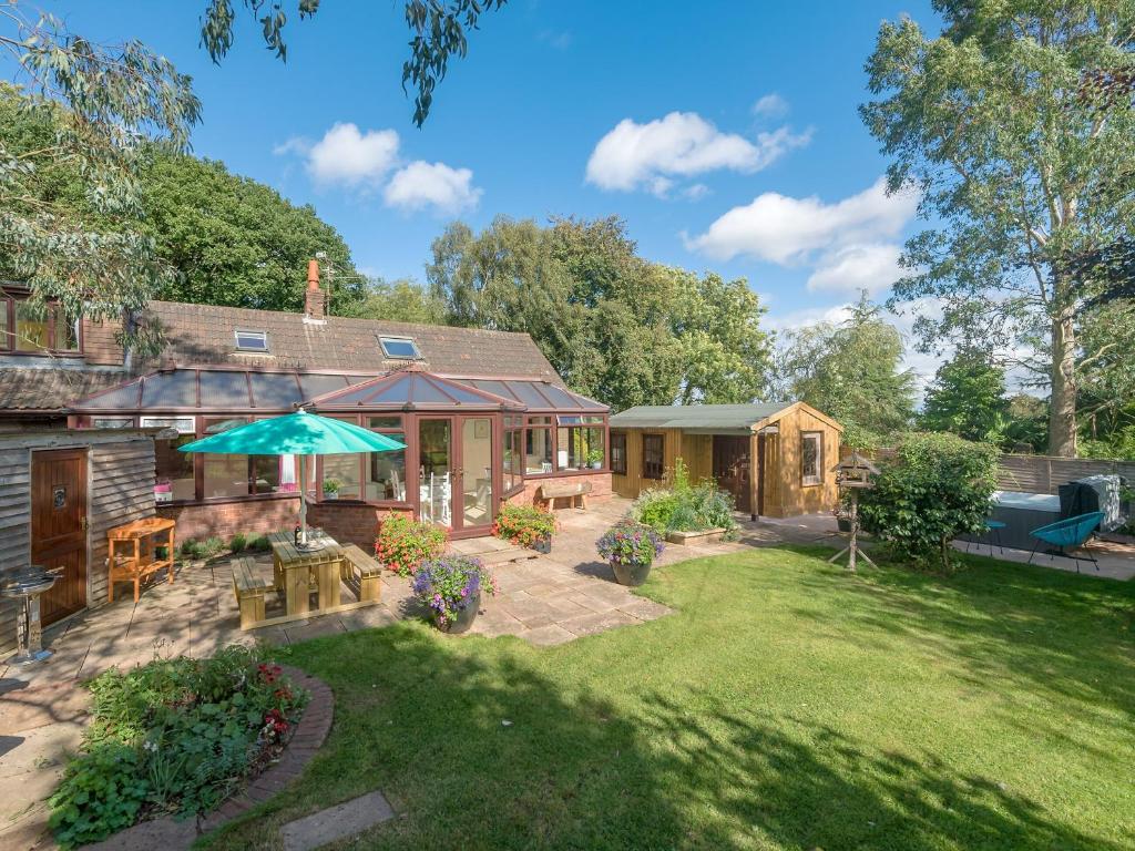 a backyard with a house and an umbrella at Wagtails in Milverton