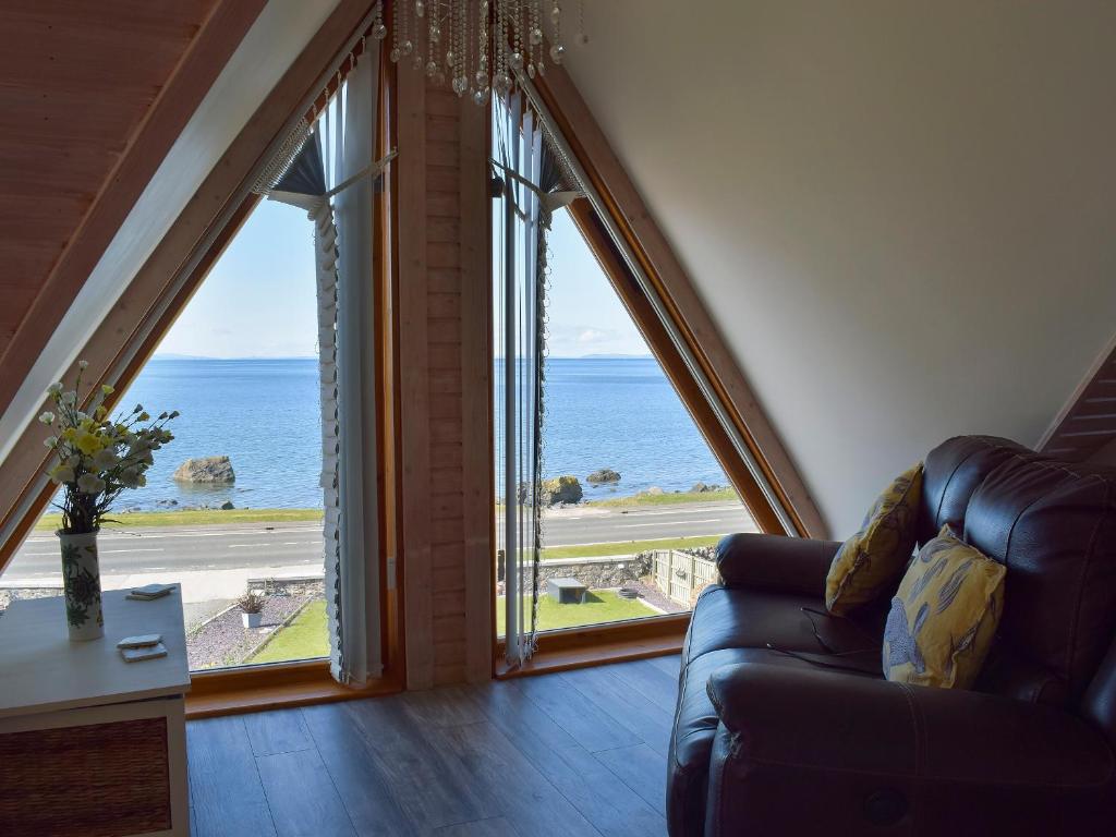 uma sala de estar com vista para o oceano em Seal Rocks em Lendalfoot