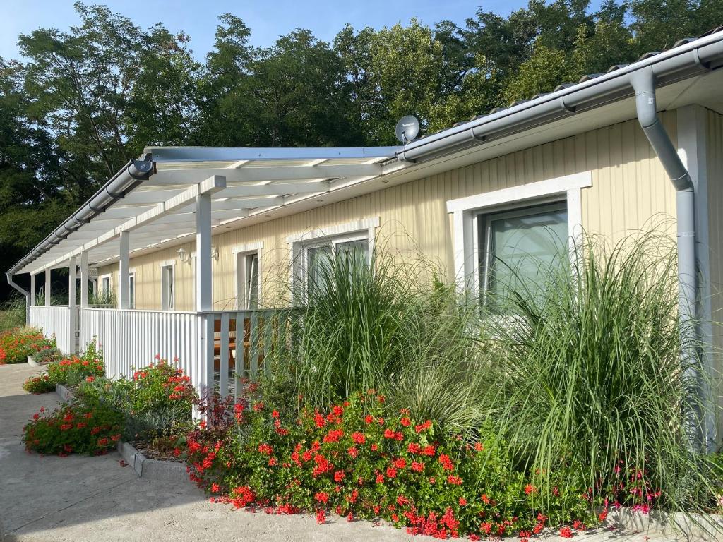 una casa con flores delante en Ferienparadies Waldidylle, Familiengeführt seit 20 Jahren - mit großem Pool und viel Platz!, en Haida