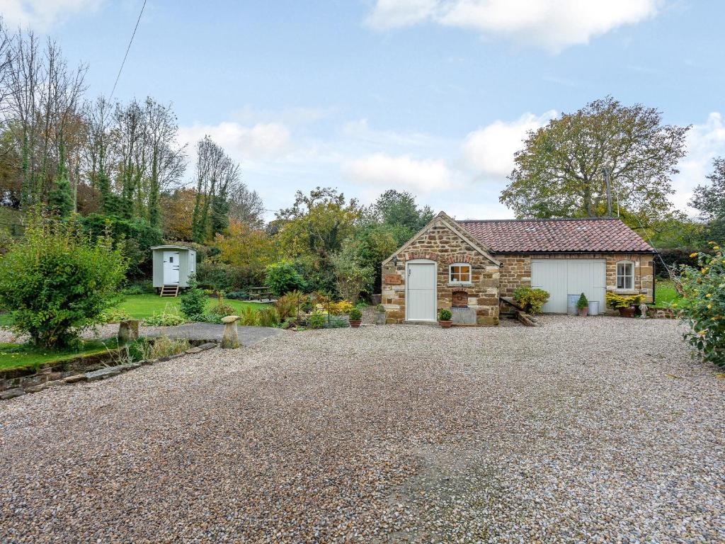 a stone driveway in front of a cottage at Wren Cottage in Sutton