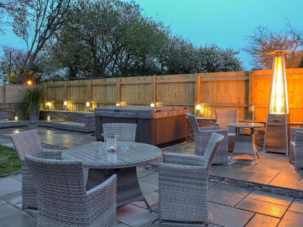 a patio with tables and chairs and a fence at Littlewood in Saint Columb Major