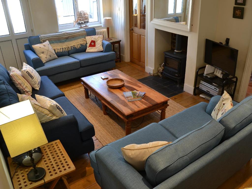 a living room with blue couches and a coffee table at Jicklings in Wells next the Sea