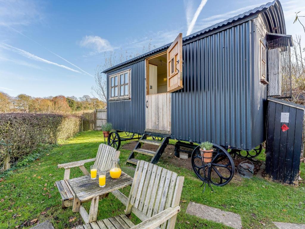 ein winziges Haus mit einem Tisch und zwei Stühlen in der Unterkunft Elsies Hut in Albourne