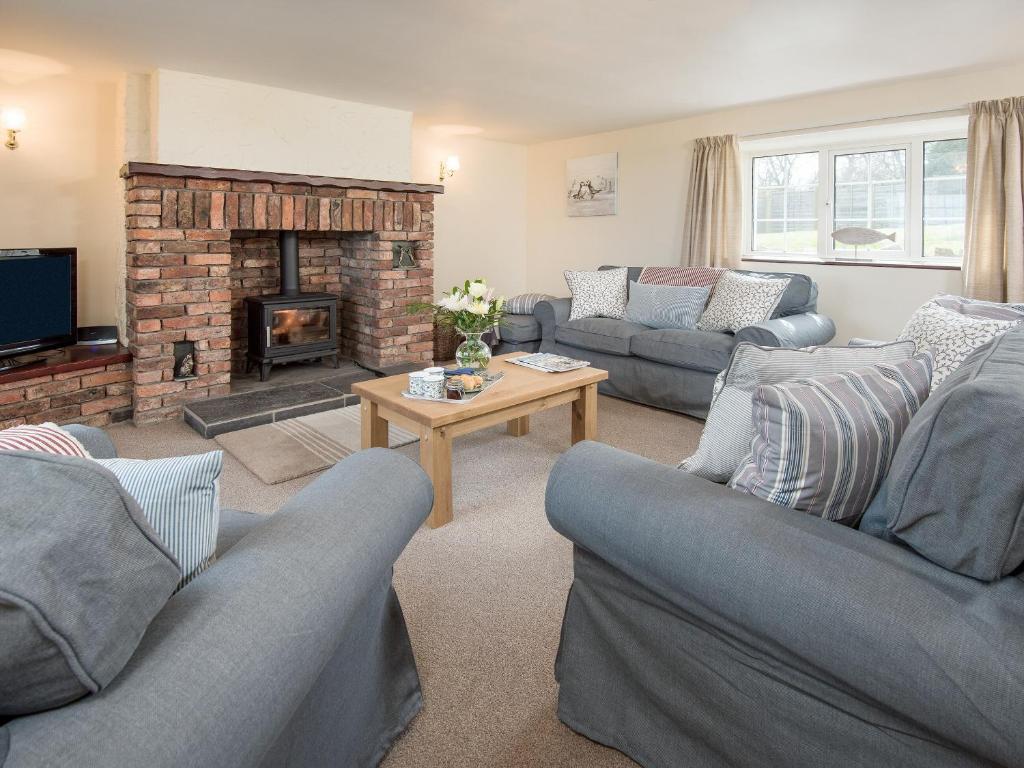 uma sala de estar com dois sofás e uma lareira em Seascape em Craster