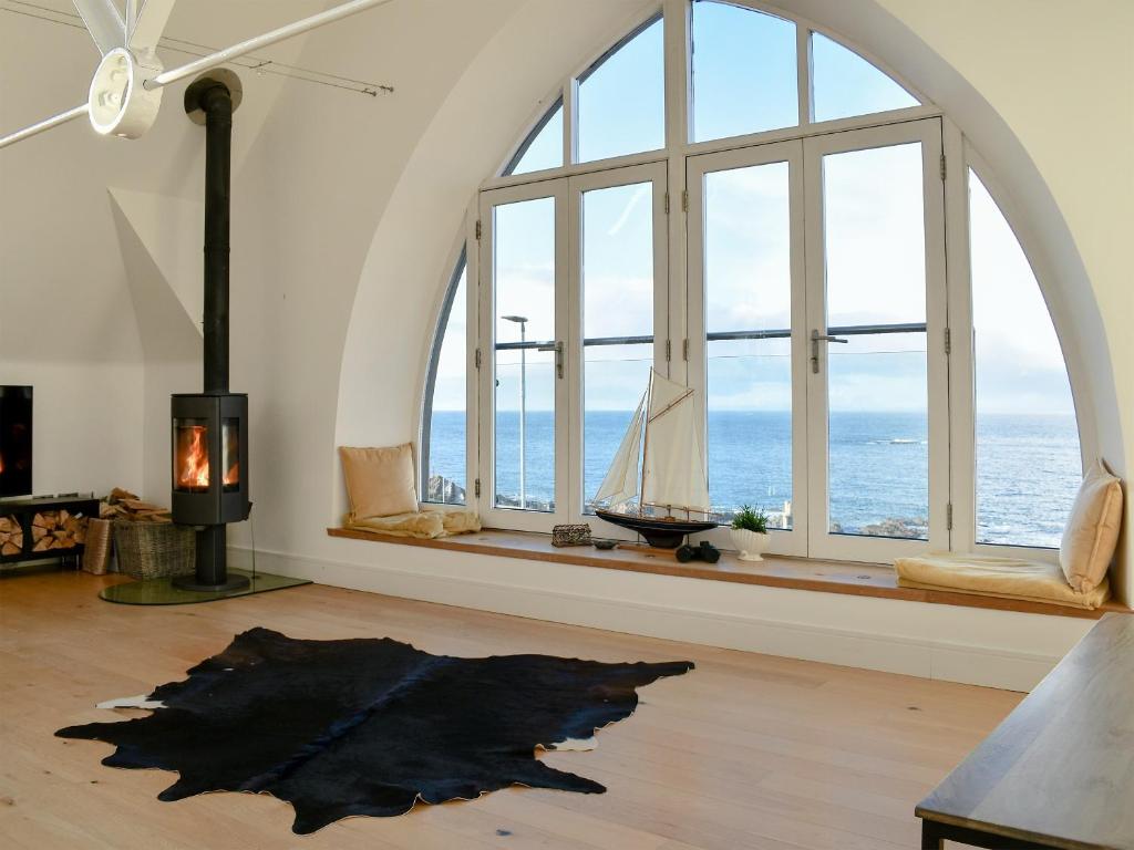 a living room with large windows and a fireplace at Rathven Parish Church Hall in Portessie