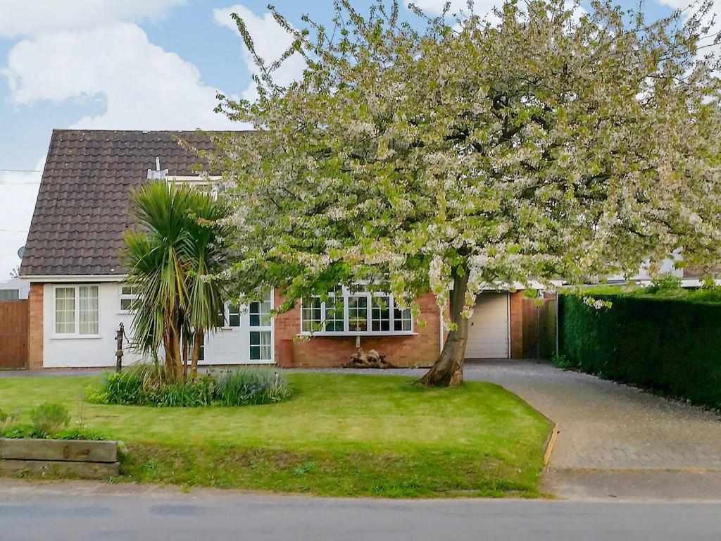 a house with a flowering tree in front of it at Dinsel in Upton