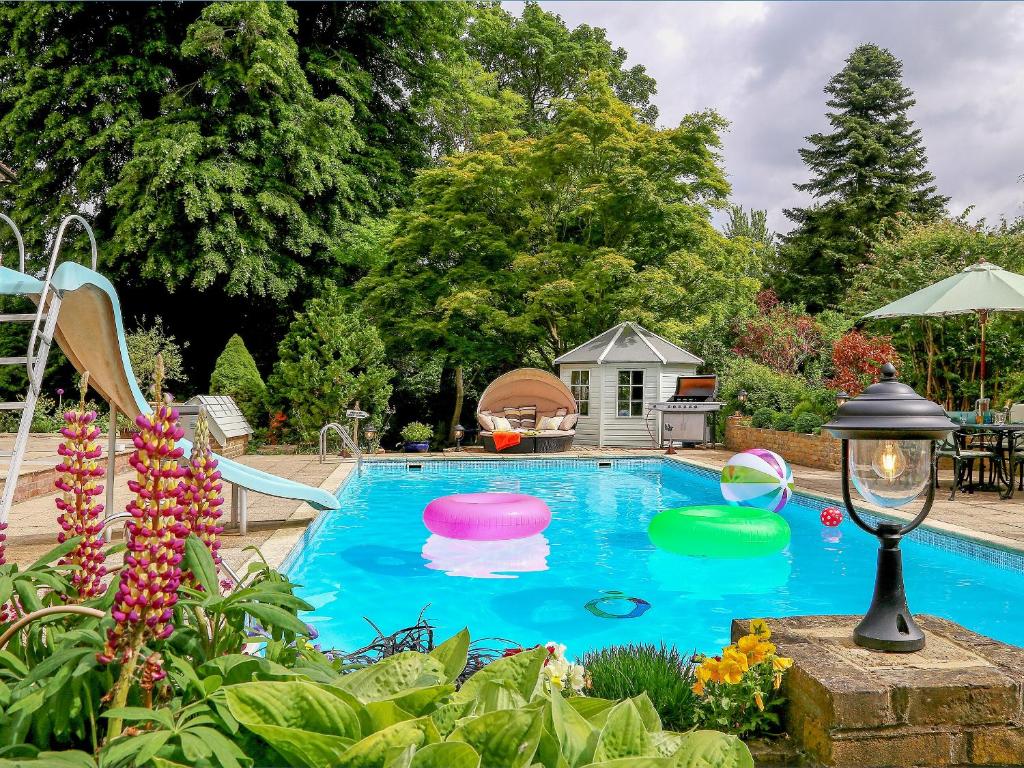 una piscina con cuatro frisbees en un patio en The Manor Coach House, en Chilham
