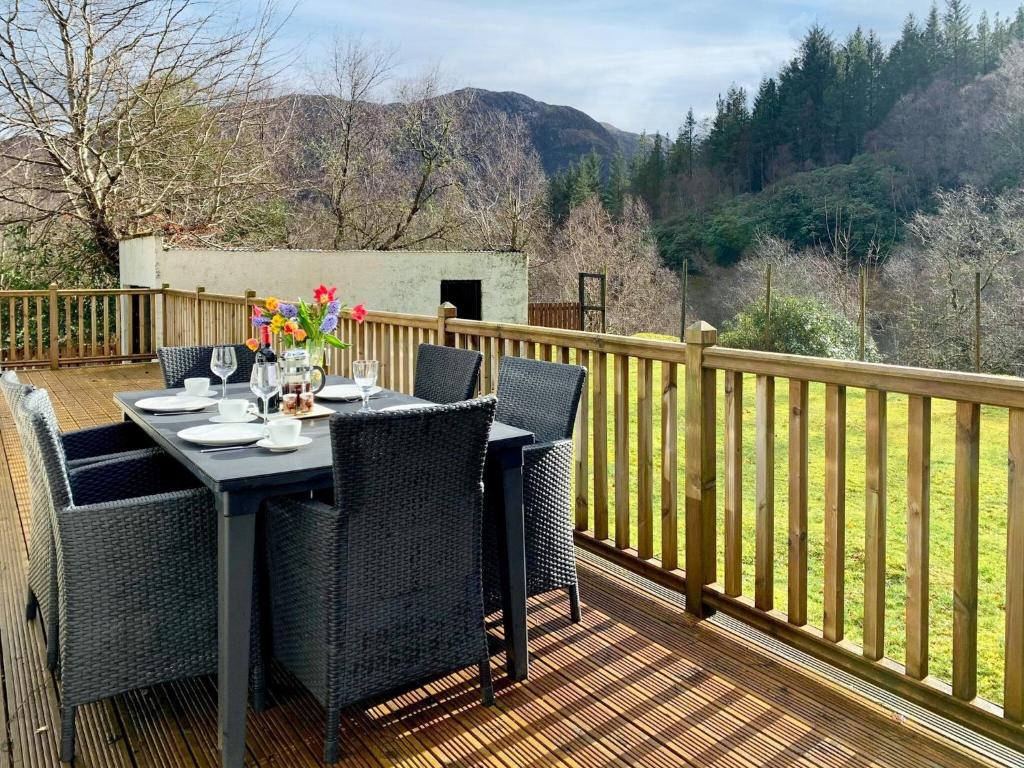 a table and chairs on a deck with a view at Torr Caladh in Glenfinnan