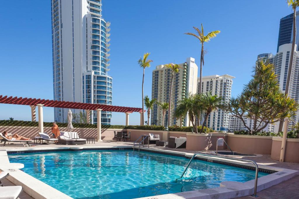 a swimming pool with city buildings in the background at King David Condominium Sunny Isles Beach in Miami Beach