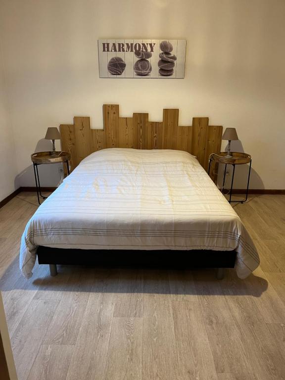 a large bed in a room with two side tables at Les mimosas in La Bresse