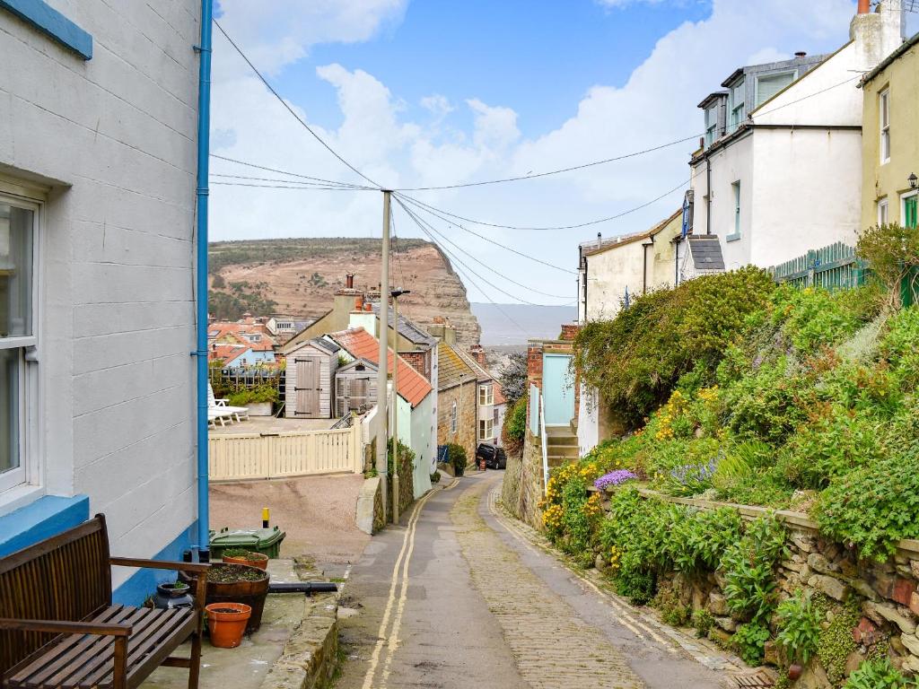 an alley with houses and a hill in the background at Felicity House in Staithes