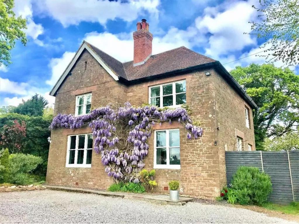 a brick house with a wreath of purple flowers on it at Spire View in Wilton